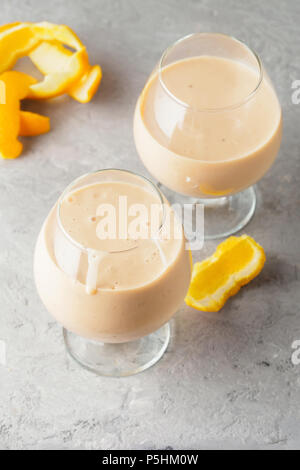 Due bicchiere da cocktail con i frullati frullato bibita salutare orange scorze di agrumi banane latte e yogurt gelato dieta sana cibo Foto Stock