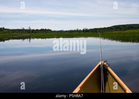 Un leggero Kevlar canoa con un fly canna da pesca galleggiante sulla baia Kunjamuk sul fiume Sacandaga nelle Montagne Adirondack, NY USA. Foto Stock