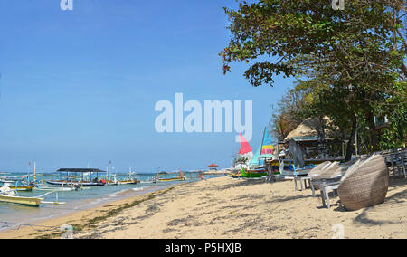 Vista panoramica della spiaggia, sedie & Barche a vela sulla spiaggia di Sanur, Bali Indonesia Foto Stock