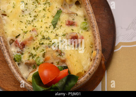 Penne alla salsa di pomodoro con carne di maiale, Mozzarella e formaggio cotto al forno in un tegame in forno Foto Stock