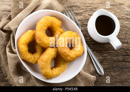 Tradizionale Picarones cileno dolci fritti fatti di zucca e farina pasta lievitata, servita con dolci chancaca zucchero di canna salsa, fotografato tettuccio Foto Stock