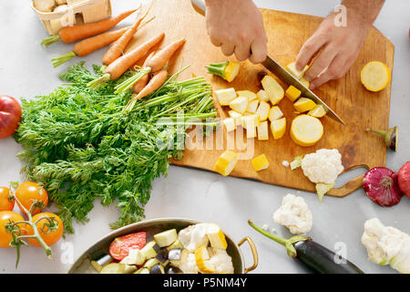 L'uomo taglia verdure per la cottura Stufato di vegetali. Ricetta cucinare cibo sano concetto Foto Stock