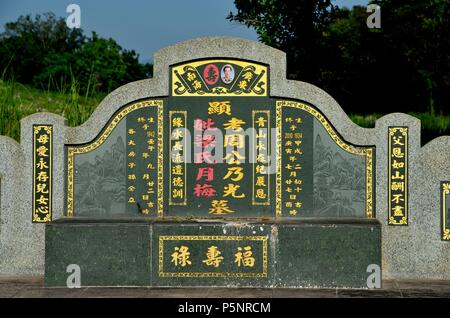 Grande tomba cinese e lapide con mandarino dorato che scrive a. cimitero Ipoh Malesia Foto Stock