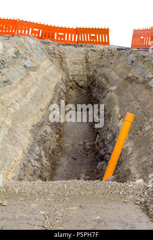 Sito in costruzione tra una grande trincea con un sacco di terra e terriccio Foto Stock