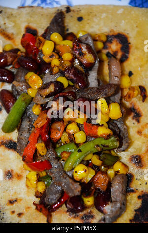 Cucina tradizionale shawarma wrap con pollo e verdure.verdure grigliate per tortilla.Rotolo di lavash sottile grigliate di carne, funghi, verdure Foto Stock
