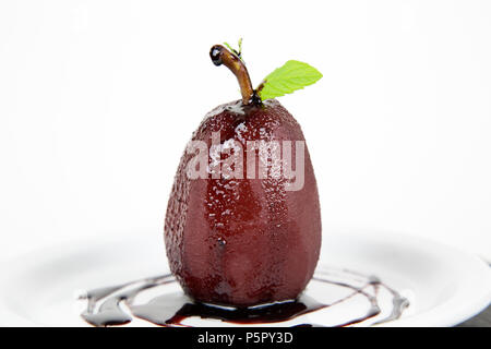 Pera affogata nel vino rosso e cannella sulla piastra Foto Stock