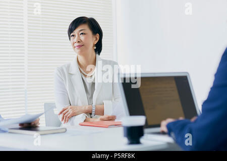 Senior giapponese imprenditrice avente riunione in ufficio Foto Stock
