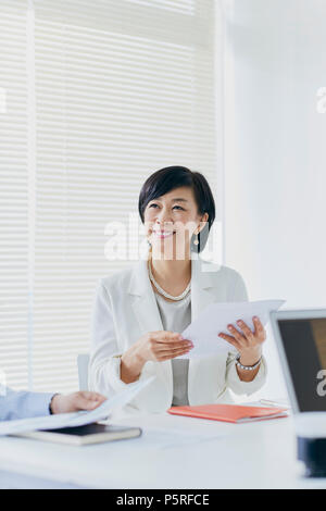 Senior giapponese imprenditrice avente riunione in ufficio Foto Stock