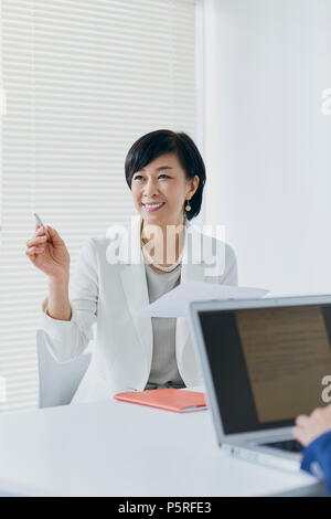 Senior giapponese imprenditrice avente riunione in ufficio Foto Stock
