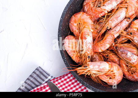 Grandi Gamberi fritti in padella. Su un tavolo bianco. Il pranzo di pesce. Spazio libero per il testo. Spazio di copia Foto Stock