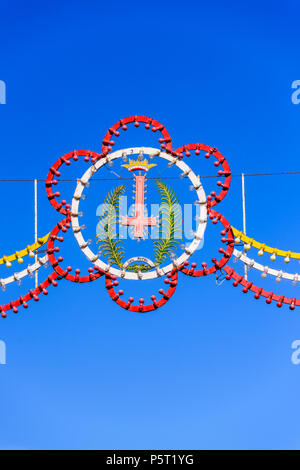 Colorate archi decorativi, con la croce capovolta di San Pietro, vengono erette per la festa di San Pietro e San Paolo di Nadur, Gozo, Malta. Foto Stock