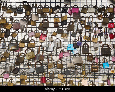 Lucchetti per amore e ricordo, lucido o arrugginito attaccato alla ringhiera del ponte che attraversa la cascata a Tampere in Finlandia Foto Stock