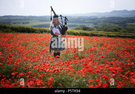 Musicista Louise Marshall riproduce le cornamuse in un campo di papavero in Midlothian, durante il lancio di una nuova composizione musicale, "Armistizio", che è stato rilasciato per un concerto a livello globale con una crowdsourced orchestra internazionale. Il pezzo sarà giocato in tutto il mondo dai musicisti volontari nel pomeriggio del Giorno del Ricordo e condiviso su social media. Foto Stock