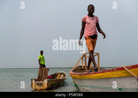Cacheu, Repubblica di Guinea Bissau - 1 Febbraio 2018: i pescatori preparano le loro canoe nel porto della città di Cacheu in Guinea Bissau. Foto Stock