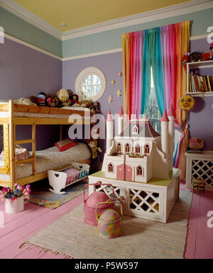 Fiaba Doll's House e letti a castello in bambini camera da letto malva con rosa pavimento verniciato e rainbow voile oscuranti sulla finestra Foto Stock