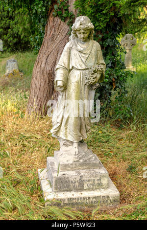 Statua di una donna vestita con la corona di fiori sul sagrato della chiesa di San Tommaso in Goring-on-Thames, Oxfordshire, Inghilterra, Regno Unito. Foto Stock