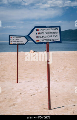 Giugno 21st, 2018 Bico das Lulas Beach, Troia, Portogallo - pali di segnaletica che indica la separazione della zona concessioned zone Foto Stock