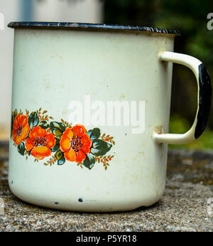 Retrò tazza da tè realizzato a partire da materiale di stagno.Rosso un fiore di arancia pattern ed ornamento del testo.un arrugginito smalto vintage mug.metallo per impieghi pesanti mug. Foto Stock