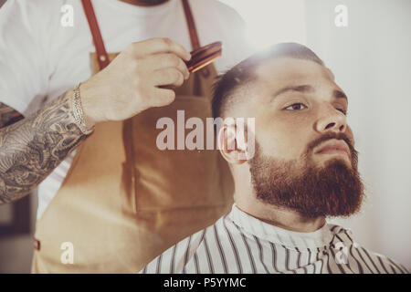 L'uomo nel processo di rifinire la barba in un barbiere. Foto in stile vintage Foto Stock