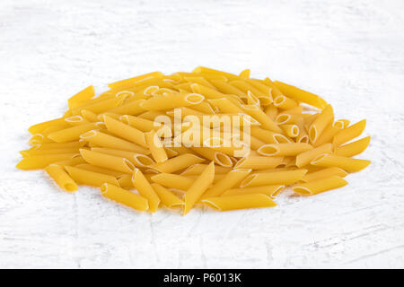 Pasta tipo penne rigate su sfondo bianco. Foto Stock