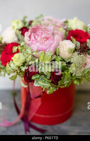 Bellissimo bouquet della molla nella scatola di testa. Disposizione con un mix di fiori. Il concetto di un negozio di fiori, una piccola azienda di famiglia. Colore rosso. Fiorista di lavoro. Foto Stock
