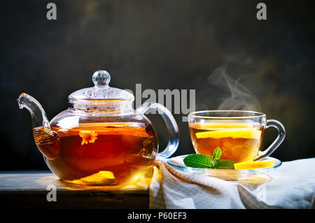 Tazza di appena infuso di tè nero,calda luce morbida, più scuro dello sfondo. Foto Stock