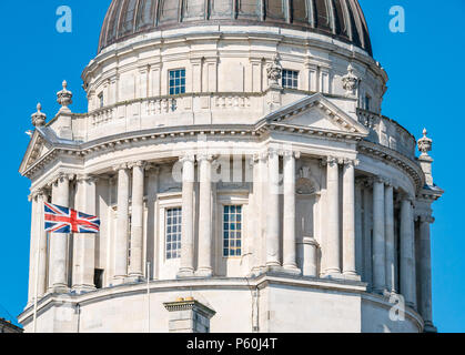 Vista ravvicinata della cupola in stile barocco edoardiano dell'edificio di Liverpool con bandiera Union Jack in volo e cielo blu Foto Stock