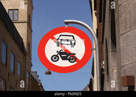 Il passaggio di autoveicoli e di motocicli è vietato. Round il bianco e il rosso segno di traffico in una città con il cielo azzurro sfondo. Foto Stock