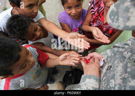 Stati Uniti Esercito Sgt Master. Andres Canales dare bambini locali candy pur promuovendo oltre l'orizzonte a San Rafael, Guatemala, Aprile 1, 2016. Task Force il lupo rosso e l'esercito a sud conduce civile umanitario Assistenza Formazione per includere il livello tattico di progetti di costruzione e preparazione medica Esercizi di formazione fornendo accesso a medici e la costruzione di scuole in Guatemala con il governo del Guatemala e non-agenzie governative dal 05MAR16 a 18GIU16 al fine di migliorare la disponibilità di missione delle forze degli Stati Uniti e di fornire un beneficio duraturo per il popolo del Guatemala. (U.S. Esercito foto di Sgt. Ro Foto Stock