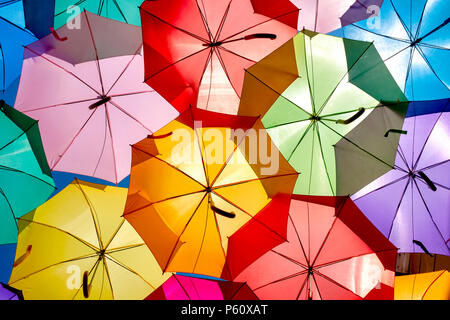 In prossimità di alcuni ombrelloni colorati appesi in Agueda, Portogallo Foto Stock