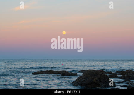 Mousehole, Cornwall, Regno Unito. Il 27 giugno 2018. Regno Unito Meteo. La quasi completa delle fragole "Luna", sorge sul mare a Mousehole al tramonto di questa sera. Credito: cwallpix/Alamy Live News Foto Stock