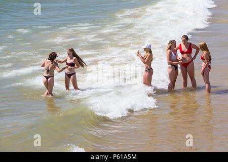 Bournemouth Dorset, Regno Unito. Il 28 giugno, 2018. Regno Unito: meteo sunseekers testa per le spiagge a Bournemouth su un altro caldo giorno soleggiato con ininterrotta in un cielo azzurro e sole. Una lieve brezza rende il calore più sopportabile. Un gruppo di amici in succinti bikini divertirsi giocando in mare e scattare foto. Credito: Carolyn Jenkins/Alamy Live News Foto Stock