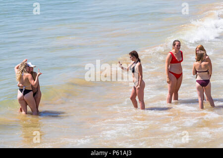 Bournemouth Dorset, Regno Unito. Il 28 giugno, 2018. Regno Unito: meteo sunseekers testa per le spiagge a Bournemouth su un altro caldo giorno soleggiato con ininterrotta in un cielo azzurro e sole. Una lieve brezza rende il calore più sopportabile. Un gruppo di amici in succinti bikini divertirsi giocando in mare e scattare foto. Credito: Carolyn Jenkins/Alamy Live News Foto Stock