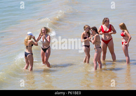 Bournemouth Dorset, Regno Unito. Il 28 giugno 2018. Regno Unito: meteo sunseekers testa per le spiagge a Bournemouth su un altro caldo giorno soleggiato con ininterrotta in un cielo azzurro e sole. Una lieve brezza rende il calore più sopportabile. Un gruppo di amici in succinti bikini divertirsi giocando in mare e scattare foto. Credito: Carolyn Jenkins/Alamy Live News Foto Stock
