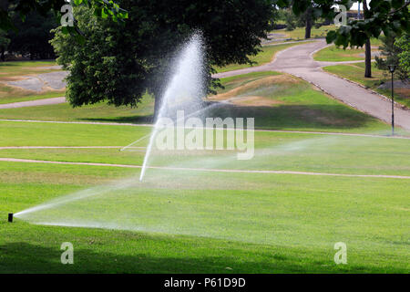 Gli sprinkler nel parco acqua l'erba in un caldo giorno d'estate in Finlandia. Foto Stock