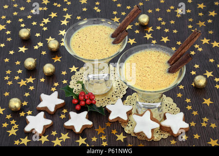 Tradizionale natale e zabaione inverno Aperitivo per due con gingerbread cookie, stella d'oro decorazioni, stagnola avvolto le sfere di cioccolato con holly sulla ruggine Foto Stock