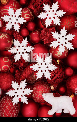 Rosso decorazioni di Natale con il simbolo del fiocco di neve bianca e baubles orso polare formando un abstract background. Natale tradizionale biglietto di auguri per la holi Foto Stock