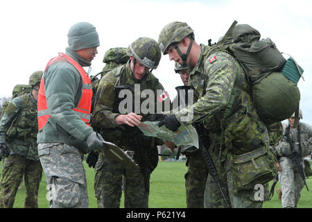 Allievi Ufficiali del Royal Military College of Canada breve un'Accademia Militare degli Stati Uniti (USMA) Cadet scorekeeper su dove il loro prossimo checkpoint saranno durante il Sandhurst annuale concorso tenutosi presso l'Accademia Militare degli Stati Uniti Apr. 8-9, 2016. Il Sandhurst la concorrenza è un evento annuale tenutosi presso l'Accademia Militare degli Stati Uniti (USMA) dove i cadetti delle accademie militari di tutto il mondo di competere in una varietà di abilità di soldato in cui Non-Commissioned Funzionari della società A e B della terza Bn., 304th Inf. Reg. (USMA) sia di guida e di valutare i cadetti sulla loro esecuzione Foto Stock