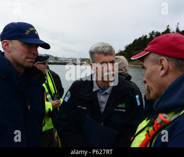 Lt. La Cmdr. Jason Hagen, capo dell'Incident Management Division di Coast Guard Settore Puget Sound, e David Byers, risposta il capo della sezione per il dipartimento di Washington di ecologia, discutere di fuoriuscite di olio i metodi di recupero con il proprietario di una nave di opportunità durante una fuoriuscita di olio esercizio di recupero vicino a Vendovi isola, nello Stato di Washington, 14 aprile 2016. Eventi come oggi esercizio sono eseguite come previsto nella zona nord-ovest del piano di emergenza in uno sforzo tra federali, statali e i partner locali e in collaborazione con l'industria per promuovere un unified, efficace e coerente risposta alle minacce potenziali f Foto Stock