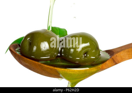 Rosso delle olive in olio al rosmarino su cucchiaio. Versare olio sul cucchiaio isolati su sfondo bianco. Foto Stock