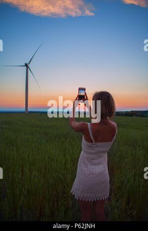 La ragazza di scattare una foto del mulino a vento Foto Stock