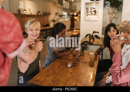 Gruppo di sorridere amiche ordinare bibite in un bistro Foto Stock