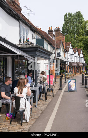 Persone seduti ai tavoli al di fuori di un ristorante in High Street, Amersham Città Vecchia, Buckinghamshire, Inghilterra, Regno Unito Foto Stock