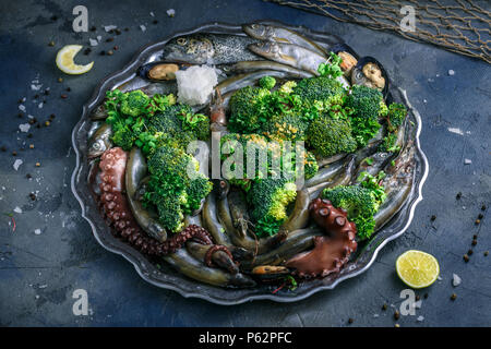 Pesce crudo: trota, polpo, gamberi e cozze su una piastra, vista dall'alto. Foto Stock