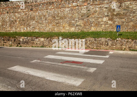 Contrassegnato attraversamento pedonale che termina in corrispondenza della parete della città di Montalcino, Val d'Orcia, Toscana, Italia. Foto Stock