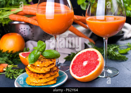 Dal succo di carote fresche e pompelmo in un bicchiere e fragrante pancake per colazione. Vitamina bere per una dieta sana. Vitamine nel cibo. Spazio di copia Foto Stock