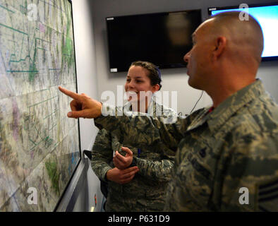 Senior Airman Nicole, XXII riconoscimento Squadron mission support analyst (MSA), spiega come MSAs utilizzare Mappe per raccogliere le informazioni necessarie per la fase di pre-flight briefing di Chief Master Sgt. Michael Ditore, ala 432nd/432nd aria ala Expeditionary command chief Aprile 1, 2016 a Creech Air Force Base in Nevada. Nicole ha spiegato come il capo ascoltato attivamente a domande e si interessavano veramente cosa il aviatori fare per la missione e come si sta facendo nella loro vita personale. (U.S. Air Force foto di Senior Airman Christian Clausen/rilasciato) Foto Stock