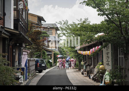 Uji, Giappone Agosto 2017: giapponese con ombrelloni su una strada di Uji. Foto Stock