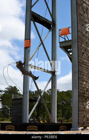 Un soldato della Guardia Nazionale calpesta la prima torre della corsia a tre torri durante l'evento Day Stakes al Best Ranger Competition 2016 di Fort Benning, Georgia. L'attività valuta le abilità tecniche di arrampicata, la forza fisica, il coordinamento e le procedure di sicurezza. La competizione di tre giorni include molteplici ostacoli, risoluzione tattica dei problemi, test di resistenza ed esercizi di lavoro di squadra per valutare la disponibilità operativa complessiva, l'efficacia e la capacità di missione dei ranger dell'esercito. Foto Stock