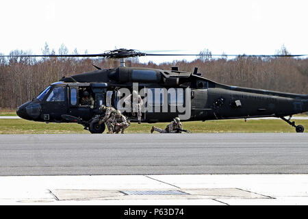 Soldati lettoni uscire rapidamente da UH-60 Blackhawk elicottero durante il carico caldo formazione, 21 aprile a Lielvarde Air Base, Lettonia. I soldati assegnati alla sede centrale e sede di truppe, 3° Stormo, 2° reggimento di cavalleria uniti alleati dalla Lettonia, Canada, Lituania e nella Repubblica federale di Germania per la formazione, che culminò con finalità speciali e corda veloce inserimento di esercizi di estrazione su un lettone Mi-17 elicottero più tardi nella giornata. I soldati delle cinque Organizzazione del Trattato del Nord Atlantico nazioni sono state conducendo una ampia gamma di corsi di formazione insieme durante il periodo estivo la protezione XIII, un anno per un periodo di due settimane interoper lungo Foto Stock